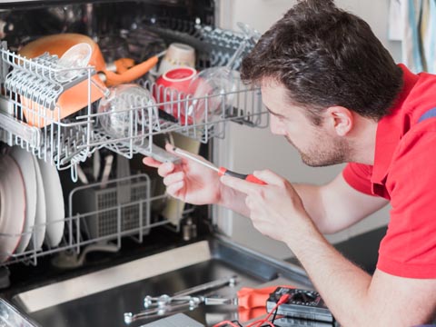 Technician working on inside of dishwasher